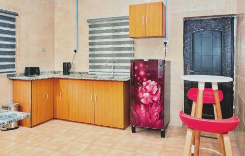 eine Küche mit einem Kühlschrank sowie einem Tisch und Stühlen in der Unterkunft Mainstream Shortlet Apartment Ltd in Gbogije