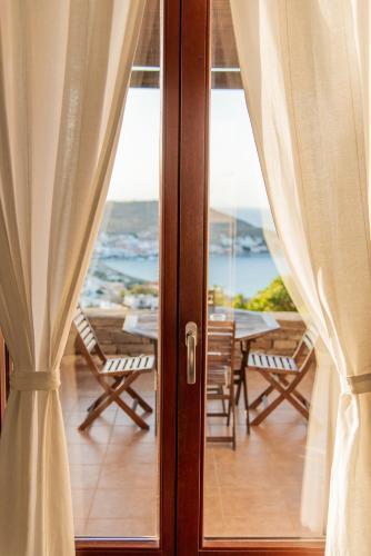 a sliding glass door with a view of a table and chairs at Villa Cavo d' Oro in Korissia