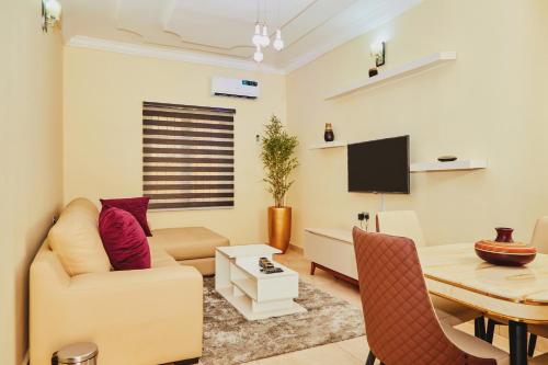 a living room with a couch and a table at Mainstream Shortlet Apartment Ltd in Gbogije