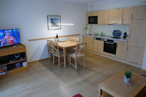 アールベックにあるFerienwohnung 1 05 Inselstrandのキッチン(テーブル、椅子、テレビ付)