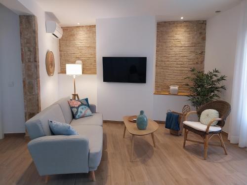 a living room with a couch and a tv at Alojamientos rurales Arbonaida in Baños de la Encina