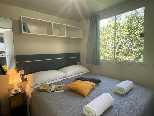 a bedroom with a bed with two pillows and a window at Camper Village in Santo Stefano al Mare