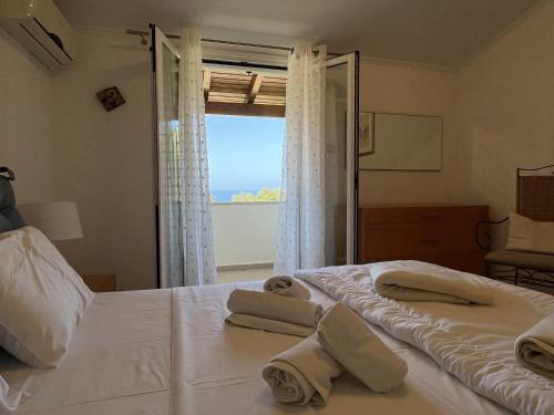 パレオカストリッツアにあるVilla Ampelaki 2のベッドルーム1室(窓のあるベッド1台にタオル2枚付)