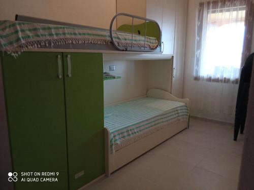 a small bedroom with a bunk bed and a green cabinet at VIA BOCCACCIO 16 in Budoni