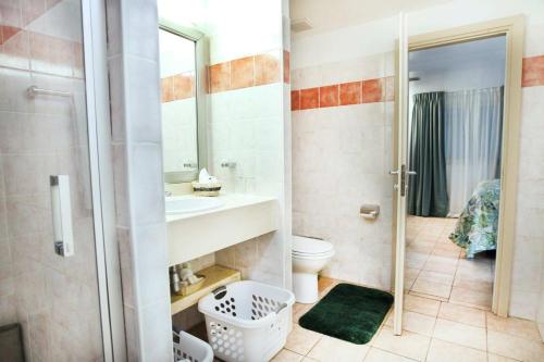a bathroom with a shower and a sink and a toilet at Royal Islander Club Resort La Terrasse in Lowlands