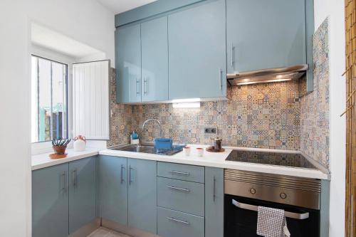 een keuken met blauwe kasten en een wastafel bij Casa Barroca in Alte