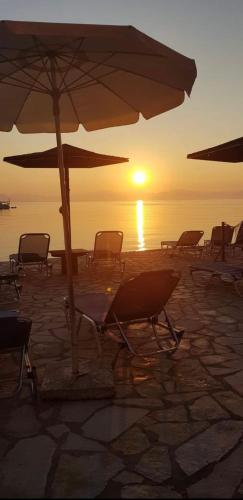 a group of chairs and an umbrella on a beach at River Beach House in Mesongi