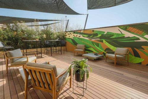 una terrazza con sedie, tavoli e ombrellone di AR Prestige Penthouse - TriBeCa Loft a Bergamo