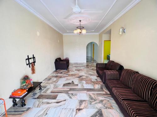 a living room with a couch and a tile floor at MH Homestay No2 at Alor Setar in Alor Setar