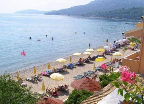 a beach with umbrellas and people in the water at River Beach House in Mesongi