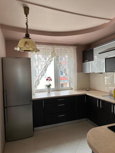 d'une cuisine équipée d'un réfrigérateur noir et d'une fenêtre. dans l'établissement Apartament Poręba, à Lublin
