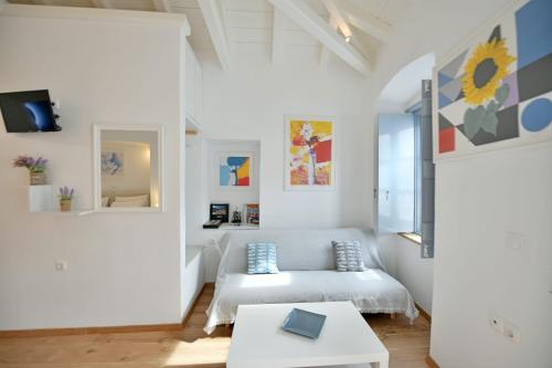 a white living room with a couch and a table at Centrál in Hydra