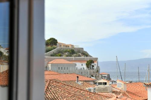 a view of the roofs of a town with a house on a hill at Centrál in Hydra