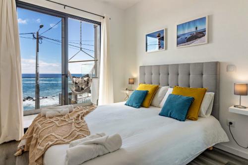 um quarto com uma cama e vista para o oceano em Casa Homem do Mar em Paul do Mar