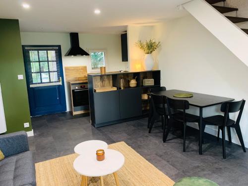 een keuken en eetkamer met een tafel en stoelen bij Cottage in Missillac