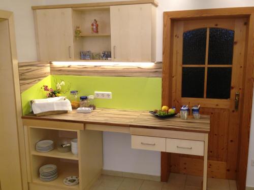 eine Küche mit einer Theke mit einer grünen Wand in der Unterkunft Gästehaus Karassowitsch in Rust