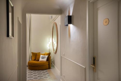 a hallway with a yellow chair and a mirror at Ricasoli Garden Relais in Florence