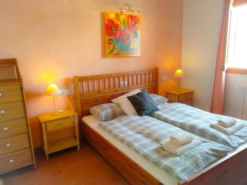 ein Schlafzimmer mit einem Bett mit zwei Nachttischen und zwei Lampen in der Unterkunft Casa Caliente in Cala Santanyi