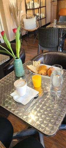 a silver table with a tray of food on it at Hôtel l'Etoile in Le Grau-du-Roi