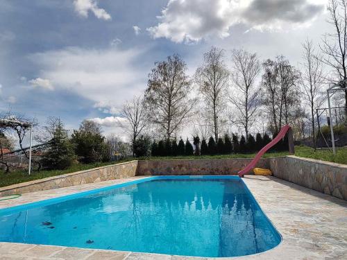 una piscina con un tobogán de agua en un patio en Kuća u selu sa bilijar salom za aktivan odmor, en Mionica