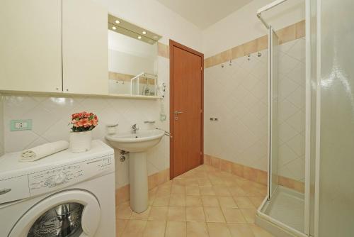een badkamer met een wasmachine en een wastafel bij Benaco Village P1-42 by Wonderful Italy in Toscolano Maderno