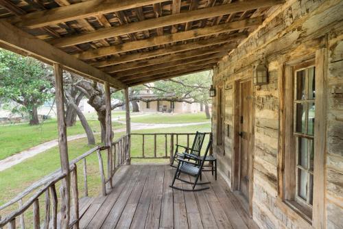 a porch of a log cabin with a bench on it at Contigo Ranch Fredericksburg in Fredericksburg
