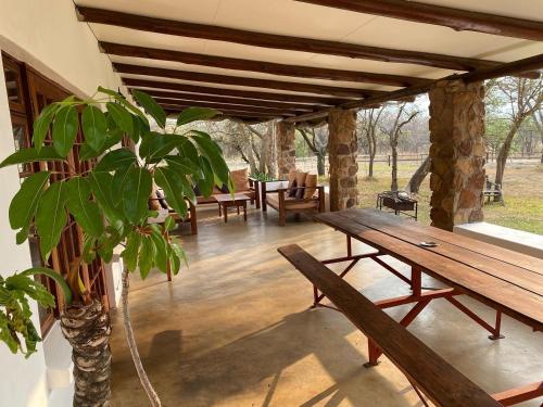 um alpendre com uma mesa de madeira e um vaso de plantas em Waterberg Cottages, Private Game Reserve em Vaalwater