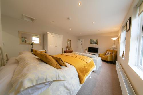 a bedroom with a large bed with a yellow blanket at Kelvin House in Fleetwood