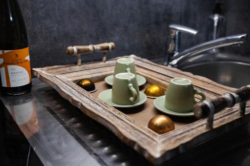 a tray with cups and spoons on a kitchen counter at Charmant Studio à Neuilly-sur-Marne in Neuilly-sur-Marne