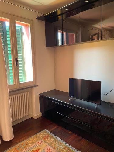 - un salon avec un bureau et une télévision à écran plat dans l'établissement VIA BRASCHI SESSANTASEI, à Cesena