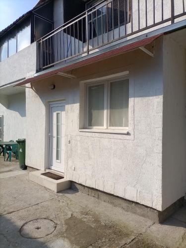 a white building with a balcony and a door at Dvoriste Danguba in Nova Pazova