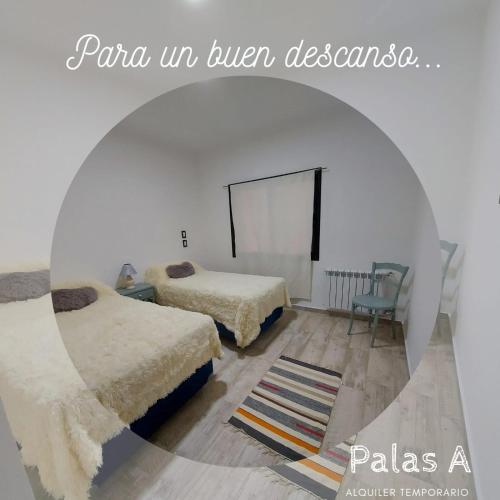 a room with two beds and a chair in it at Palas A in Venado Tuerto