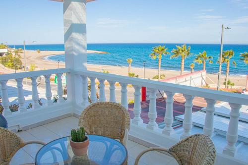 d'un balcon avec une table et des chaises donnant sur l'océan. dans l'établissement La Esperanza Beach- Zona Pubs y Restaurantes, à Mojácar