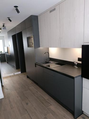 a kitchen with white cabinets and a black counter top at Apartament 3 Maj 5 in Gorlice