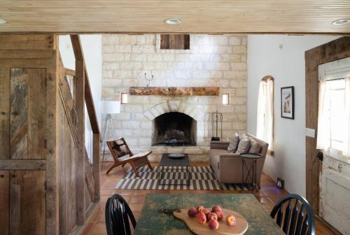 a living room with a table and a fireplace at Contigo Ranch Fredericksburg in Fredericksburg