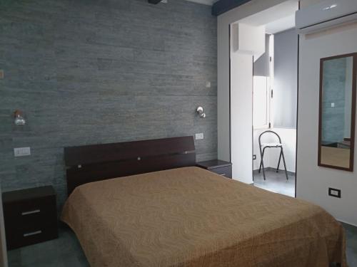 a bedroom with a bed and a brick wall at CASA VACANZE HUGO in Botricello