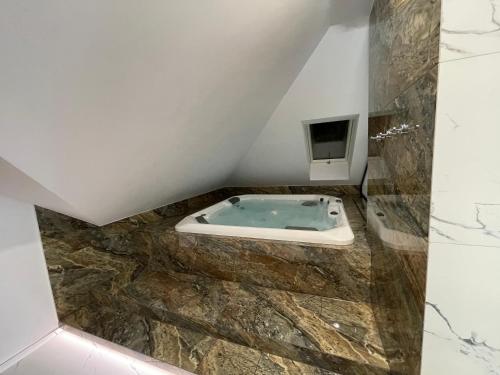 uma casa de banho com jacuzzi no sótão em Mały Książę em Podzamcze