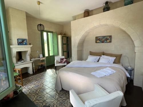 a bedroom with a large white bed and a chair at Boutique Hotel Masseria Sottomasi in Savelletri di Fasano