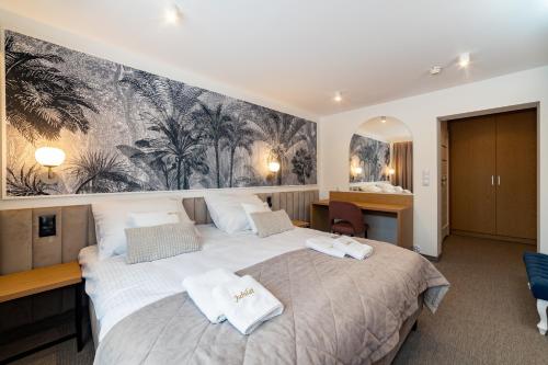 a bedroom with a large bed with towels on it at Hotel Jubilat in Zamość
