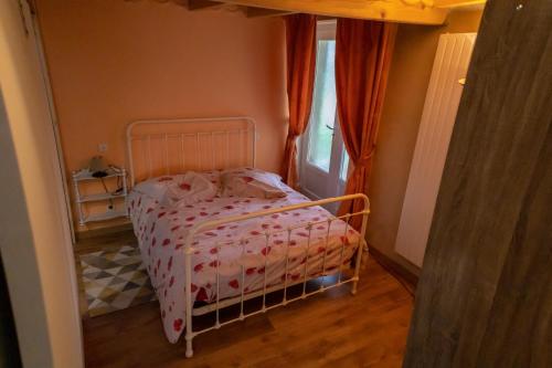 ein kleines Schlafzimmer mit einem Bett mit einer rosa Decke in der Unterkunft Les collines 