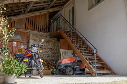 a motorcycle parked in front of a house with a staircase at Les collines 