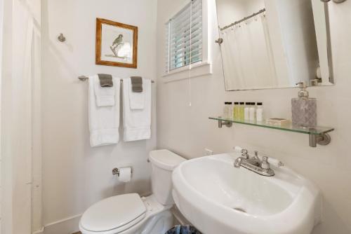 a white bathroom with a toilet and a sink at Seashore Studio in San Diego
