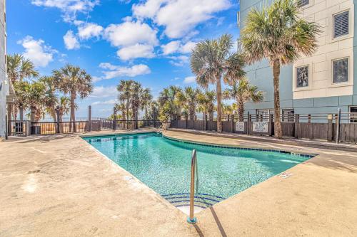 a swimming pool with palm trees in front of a building at Sun N Sand 607 in Myrtle Beach