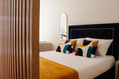 Un dormitorio con una cama grande con almohadas de colores. en Fish Village Deluxe, en Vila Nova de Gaia