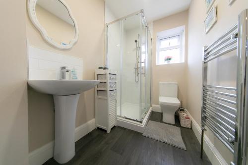 a bathroom with a sink and a shower and a toilet at Kelvin House in Fleetwood