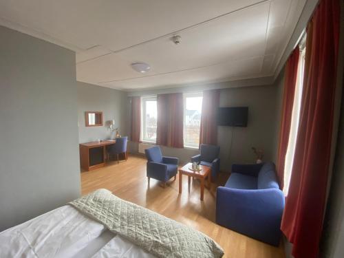 um quarto de hotel com uma cama e cadeiras e uma sala de estar em Horten Budget Hotel em Horten