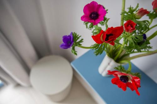 a blue table with flowers in a vase on it at Porto Bello di Paros in Parikia