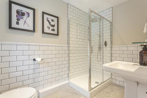 a bathroom with a shower and a toilet and a sink at The Old Mill Inn in Dearham