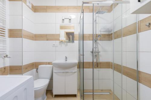 a bathroom with a shower and a toilet and a sink at Coast Breeze Apartment by Renters in Kołobrzeg