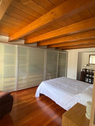 a bedroom with a white bed and wooden ceilings at La Luna nei Sassi in Matera